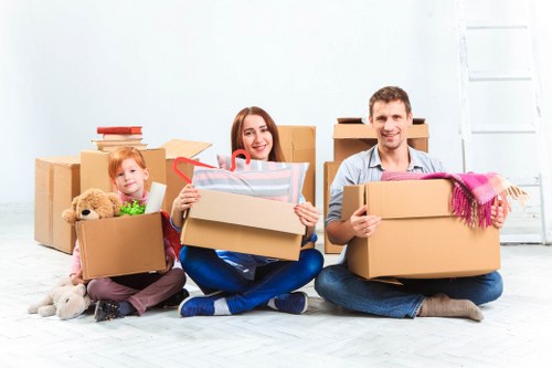 Removalists carrying furniture down a Hackney staircase